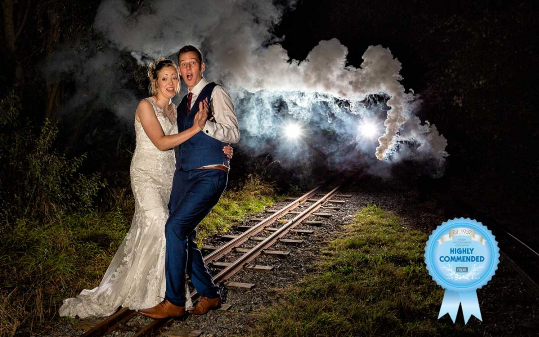 Bride and groom on the railway track looking scared as a train is coming during their wedding at Wat Tyler Country Park