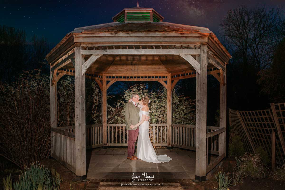 Night portrait of the bride and groom under the gazebo