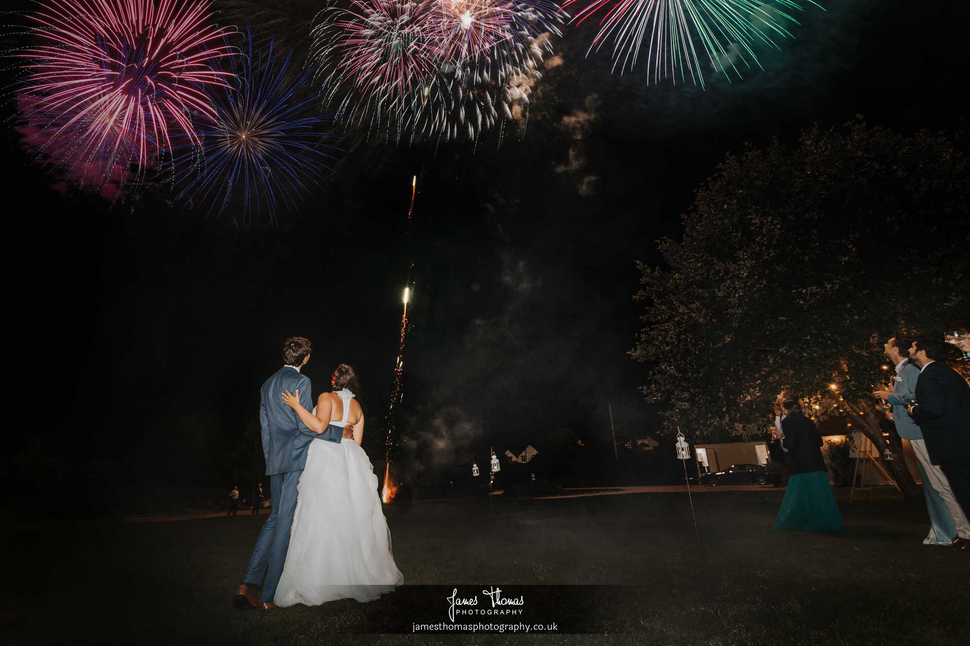 Bride and groom watching a firework display on their wedding day