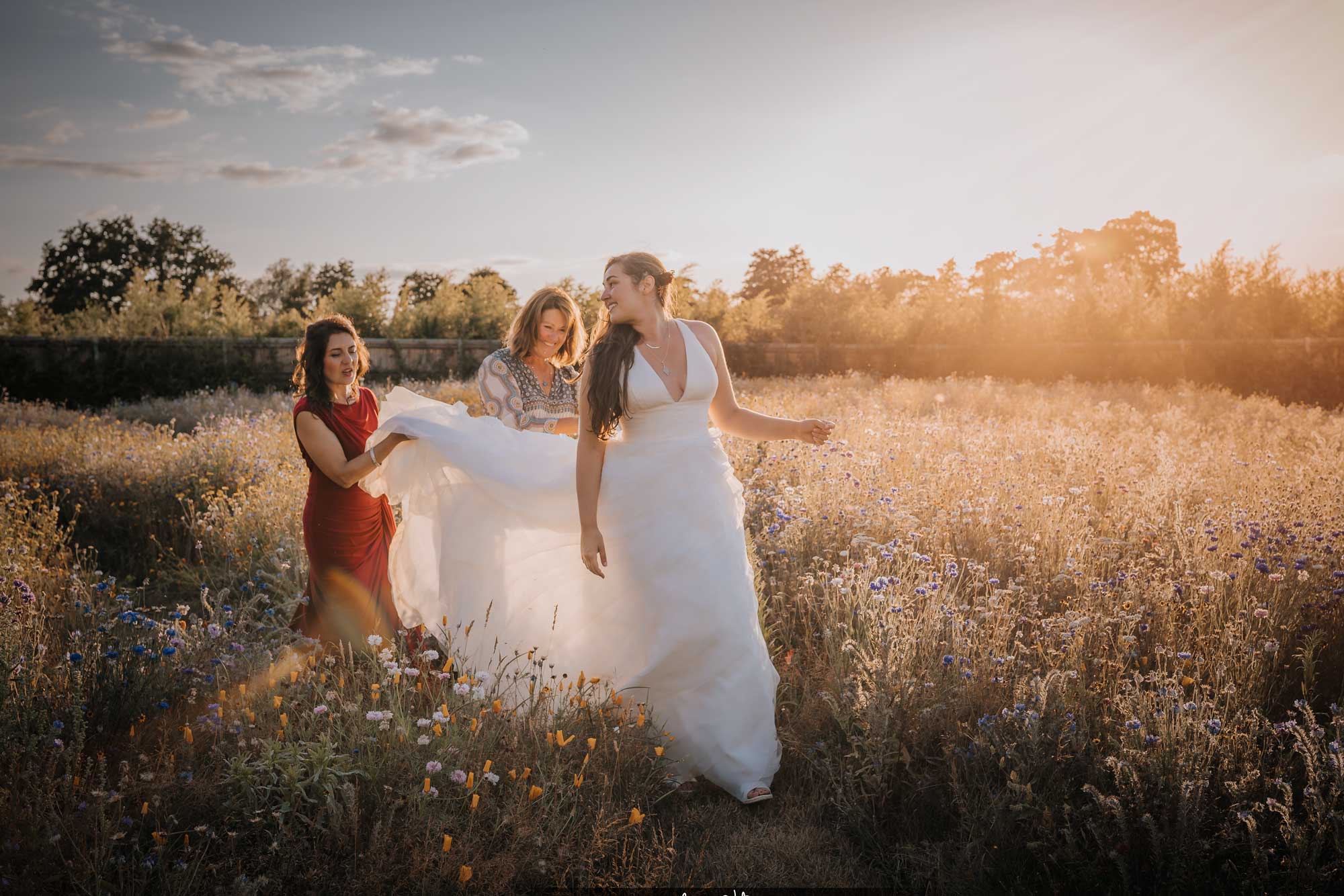 Bride with her girls walking through a wildflower meadow at golden hour