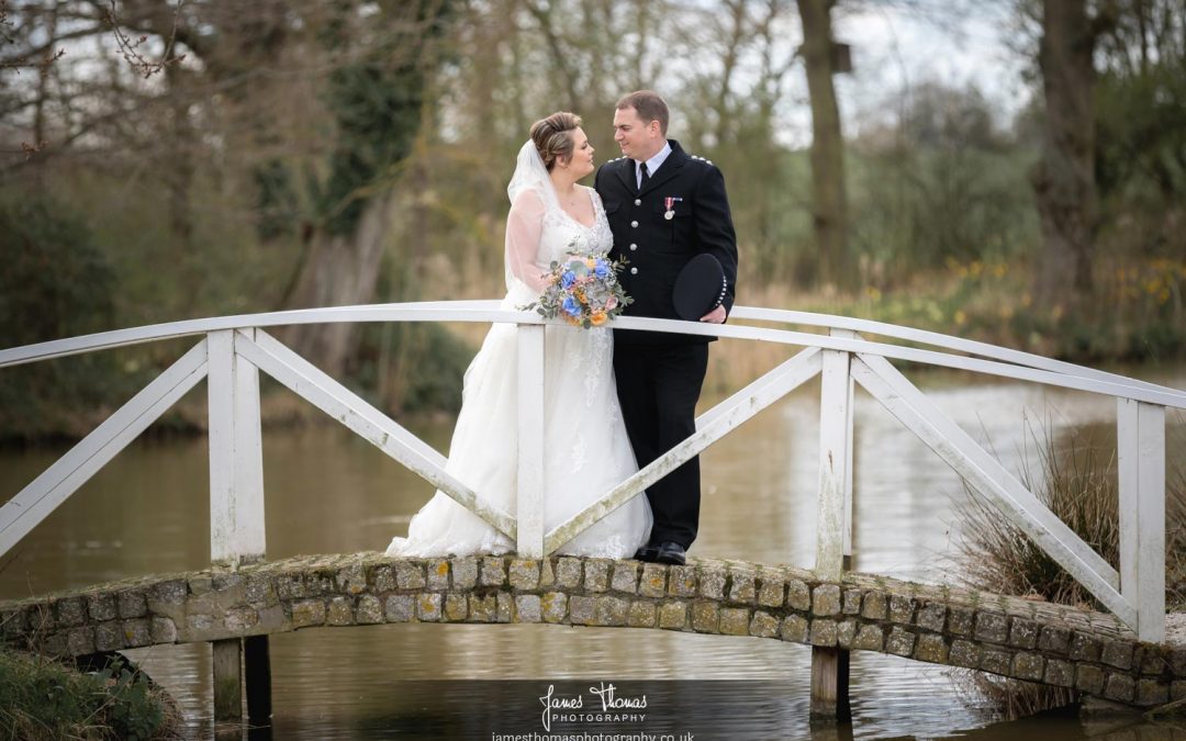 Bride and Groom standing on a bridge at Villiers Barn Wedding Venue