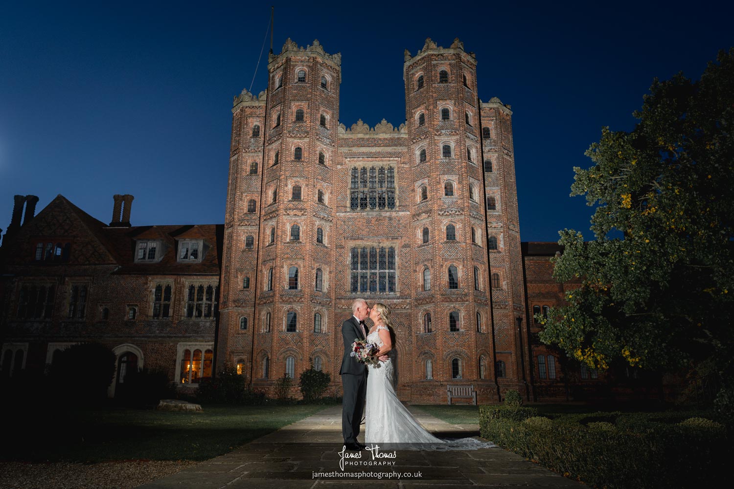 Bride and Groom at night outside Layer Marney Tower